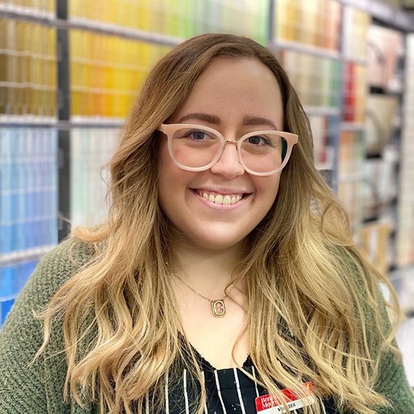 Headshot of Vanessa Bartoli, in front of the paint color chip display at Barrydowne Paint in Sudbury, Ontario.