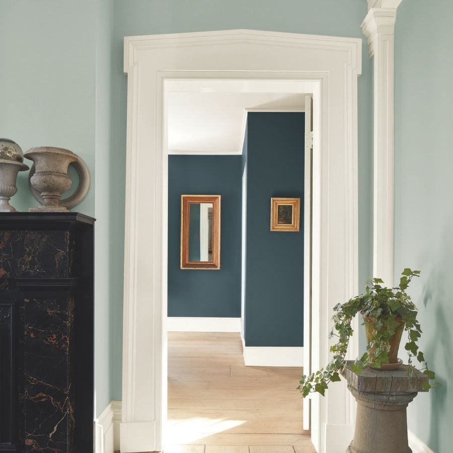 Doorway of sitting room walls painted in a light pale blue green hue, Benjamin Moore's Raindance. View of adjoining room painted in Benjamin Moore Narragansett Green is visible in the frame.